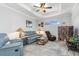 Living room with leather furnishings, ceiling fan, and neutral tile flooring at 16450 Bauers Ave, Port Charlotte, FL 33954