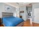 Comfortable bedroom with wood floors, a queen-size bed with blue comforter, and views to the ensuite bathroom at 16450 Bauers Ave, Port Charlotte, FL 33954