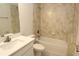 Tiled bathroom with shower-tub combo and a sleek white countertop at 17374 Gadsen Ave, Port Charlotte, FL 33948