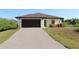 Charming one-story house with a brick-paved driveway, dark brown garage door and neatly trimmed landscaping at 17374 Gadsen Ave, Port Charlotte, FL 33948