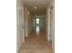 Bright hallway with neutral walls, tiled floor, and recessed lighting leading to the open living space at 17374 Gadsen Ave, Port Charlotte, FL 33948