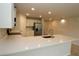 Modern kitchen features an island bar, sleek white cabinets, stainless steel appliances and quartz countertops at 17374 Gadsen Ave, Port Charlotte, FL 33948