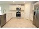 Well-lit kitchen featuring stainless steel appliances, white cabinetry, and tiled flooring at 17374 Gadsen Ave, Port Charlotte, FL 33948