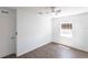 Cozy bedroom featuring hardwood floors, a ceiling fan, white walls, and a convenient door for easy access at 182 Dowling Ne Ave, Port Charlotte, FL 33952