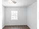 Simple bedroom featuring hardwood floors, a window, and white walls, offering a versatile living space at 182 Dowling Ne Ave, Port Charlotte, FL 33952