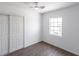 Bedroom featuring hardwood floors, a ceiling fan, window with a view, and a closet with sliding doors at 182 Dowling Ne Ave, Port Charlotte, FL 33952