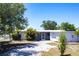 Exterior of single-story home with a driveway and mature trees in a well-maintained yard at 182 Dowling Ne Ave, Port Charlotte, FL 33952