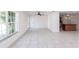 Spacious living room with large window, tile floors, ceiling fan, and access to kitchen at 182 Dowling Ne Ave, Port Charlotte, FL 33952