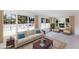 Staged living room featuring lots of windows, water views, modern furniture, and neutral decor at 182 Dowling Ne Ave, Port Charlotte, FL 33952