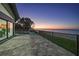 Wide backyard paved patio with glass sliding doors overlooks calm bay water at 1820 Jamaica Way, Punta Gorda, FL 33950