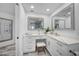 Bright bathroom featuring double vanity, white cabinetry, mirrors, and stylish stool at 1820 Jamaica Way, Punta Gorda, FL 33950