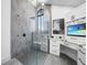 Modern bathroom features glass shower, dual sinks, and sleek white cabinets with black hardware at 1820 Jamaica Way, Punta Gorda, FL 33950