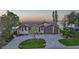 Stunning waterfront home featuring lush landscaping, brick driveway, and a charming tile roof at 1820 Jamaica Way, Punta Gorda, FL 33950