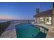 Inviting pool area with a view of the serene bay at twilight from the backyard patio at 1820 Jamaica Way, Punta Gorda, FL 33950