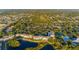 Community aerial view showing condos, lake, greenery, pool, and tennis courts at 19375 Water Oak Dr # 106, Port Charlotte, FL 33948