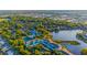 Expansive aerial view shows the community near a lake and surrounded by lush trees, including a tennis court and pool at 19375 Water Oak Dr # 106, Port Charlotte, FL 33948