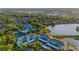 Aerial view showcasing condos near a lake, pool, and tennis courts amid lush greenery, promoting a vibrant community lifestyle at 19375 Water Oak Dr # 106, Port Charlotte, FL 33948