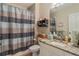 Bathroom with shower, decorative striped curtain, granite countertop, and a framed mirror at 19375 Water Oak Dr # 106, Port Charlotte, FL 33948