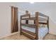 Neutral bedroom featuring a wooden bunk bed with blue striped bedding and a window with blackout curtains at 19375 Water Oak Dr # 106, Port Charlotte, FL 33948