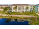 Condo building exterior with lush landscaping, palm trees and tranquil waterfront setting at 19375 Water Oak Dr # 106, Port Charlotte, FL 33948