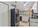 Open-concept kitchen with stainless steel refrigerator, granite counters, and white cabinetry at 19375 Water Oak Dr # 106, Port Charlotte, FL 33948