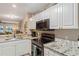 Well-lit kitchen with modern appliances, granite countertops and white cabinets at 19375 Water Oak Dr # 106, Port Charlotte, FL 33948