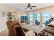 Relaxing living room featuring a large TV, comfortable seating, and sliding doors to a screened lanai overlooking the lake at 19375 Water Oak Dr # 106, Port Charlotte, FL 33948