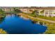 Scenic view of pond with condos in background and rock detail with plants on the side and an aeration fountain in the middle at 19375 Water Oak Dr # 106, Port Charlotte, FL 33948