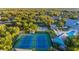 Aerial view of well-maintained tennis courts, pool, and clubhouse offering recreational amenities within a lush, green landscape at 19375 Water Oak Dr # 106, Port Charlotte, FL 33948