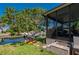 Charming home with backyard featuring a lush lawn, a large shade tree, and lanai in the background at 211 Lido Dr, Punta Gorda, FL 33950