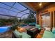 Enclosed patio with a refreshing pool, comfortable seating, and a welcoming fire feature for outdoor relaxation at 211 Lido Dr, Punta Gorda, FL 33950