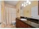 Bathroom features a vanity with granite counters, a decorative mirror and shower with curtain at 211 Lido Dr, Punta Gorda, FL 33950
