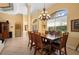 Elegant dining room with a large wooden table, chandelier, and arched windows for natural light at 211 Lido Dr, Punta Gorda, FL 33950