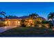 Charming home featuring a well-manicured lawn, mature trees, a spacious driveway, and a cozy two-car garage at 211 Lido Dr, Punta Gorda, FL 33950