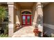 Close-up of a striking red double-door entry with glass inserts, framed by elegant columns at 211 Lido Dr, Punta Gorda, FL 33950