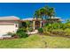 Inviting home featuring a well-manicured lawn, vibrant landscaping, and a striking red front door at 211 Lido Dr, Punta Gorda, FL 33950