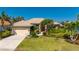 Charming home with lush landscaping, a paver driveway, and a red front door at 211 Lido Dr, Punta Gorda, FL 33950