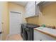 Well-equipped laundry room with washer, dryer, utility sink, and ample storage cabinets at 211 Lido Dr, Punta Gorda, FL 33950
