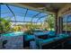 Relaxing screened-in lanai with comfortable seating, lush landscaping, and a beautiful pool with waterfall feature at 211 Lido Dr, Punta Gorda, FL 33950