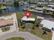 Waterfront property featuring lush landscaping, a canal view, and a charming single-story home in a desirable neighborhood at 21444 Higgs Dr, Port Charlotte, FL 33952