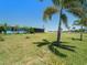 Lush backyard featuring mature palm trees, green lawn, and a screened-in lanai, offering a private and peaceful retreat at 21444 Higgs Dr, Port Charlotte, FL 33952
