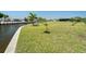 Spacious waterfront backyard featuring lush lawn and canal access, perfect for enjoying outdoor activities and relaxation at 21444 Higgs Dr, Port Charlotte, FL 33952