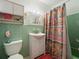 A cozy bathroom with light green tiles, a white sink, and a colorful shower curtain at 21444 Higgs Dr, Port Charlotte, FL 33952