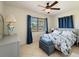A relaxing bedroom with tile floors, a ceiling fan, and blue floral bedding at 21444 Higgs Dr, Port Charlotte, FL 33952