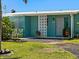 Charming home featuring a quaint patio area, teal walls, and delightful landscaping at 21444 Higgs Dr, Port Charlotte, FL 33952