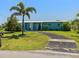 Charming single-story home with a well-manicured lawn, mature palm trees, and a welcoming facade in a quiet neighborhood at 21444 Higgs Dr, Port Charlotte, FL 33952