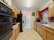 Long kitchen with tile floors, wooden cabinets, and stainless steel appliances at 21444 Higgs Dr, Port Charlotte, FL 33952