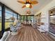 Spacious lanai featuring cozy seating areas, ceiling fans, and views of the lush backyard, perfect for relaxation at 21444 Higgs Dr, Port Charlotte, FL 33952