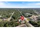 Aerial view showcases the home's location, nestled among trees, with a pond nearby at 22010 Seyburn Ter, Port Charlotte, FL 33954