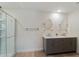 A spacious bathroom features a double vanity and a modern glass-enclosed shower for a spa-like experience at 22010 Seyburn Ter, Port Charlotte, FL 33954
